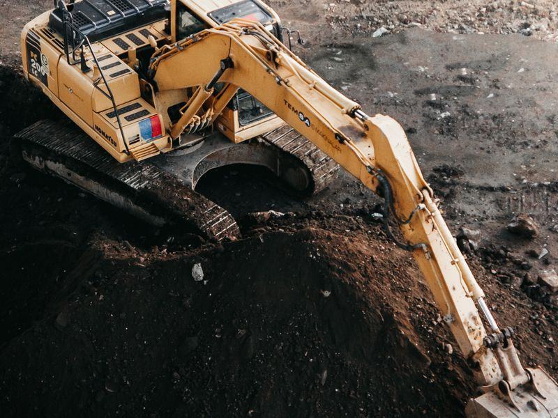 Excavator installing a French drain to move water away from a Rhode Island home
